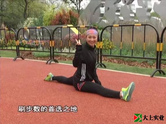 跑步愛(ài)好者小婭在塑膠跑道展示一字馬